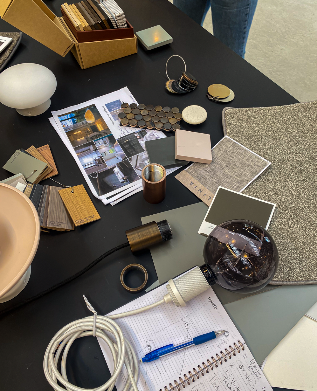 A collection of items on a table, lighting, tile, flooring and fitting samples.